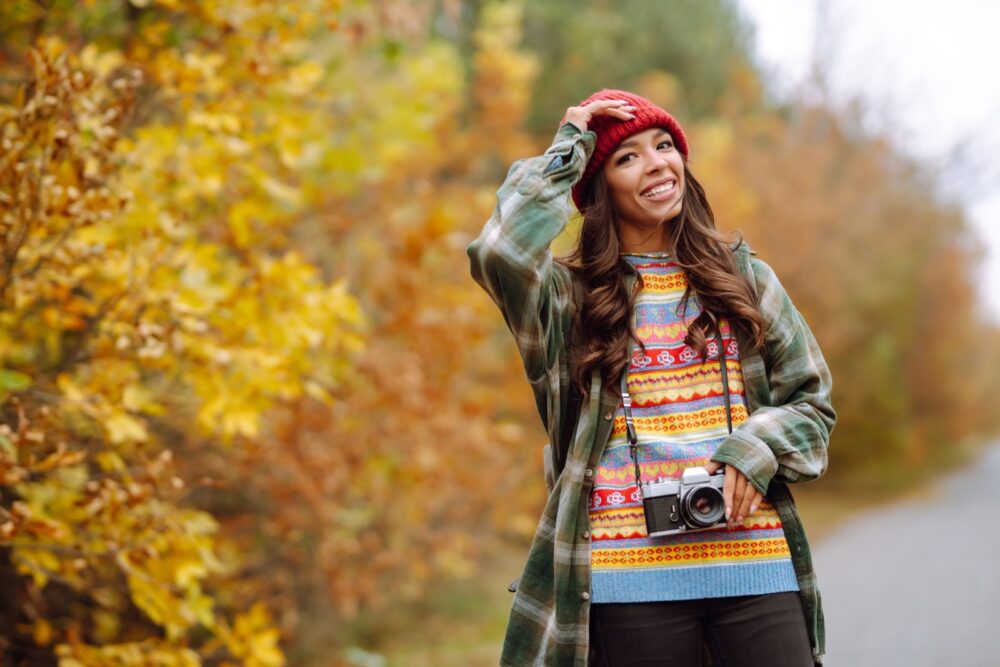 Лепа млада жена се фотографише ретро камером. Одмор, опуштање, путовања, животни стил.